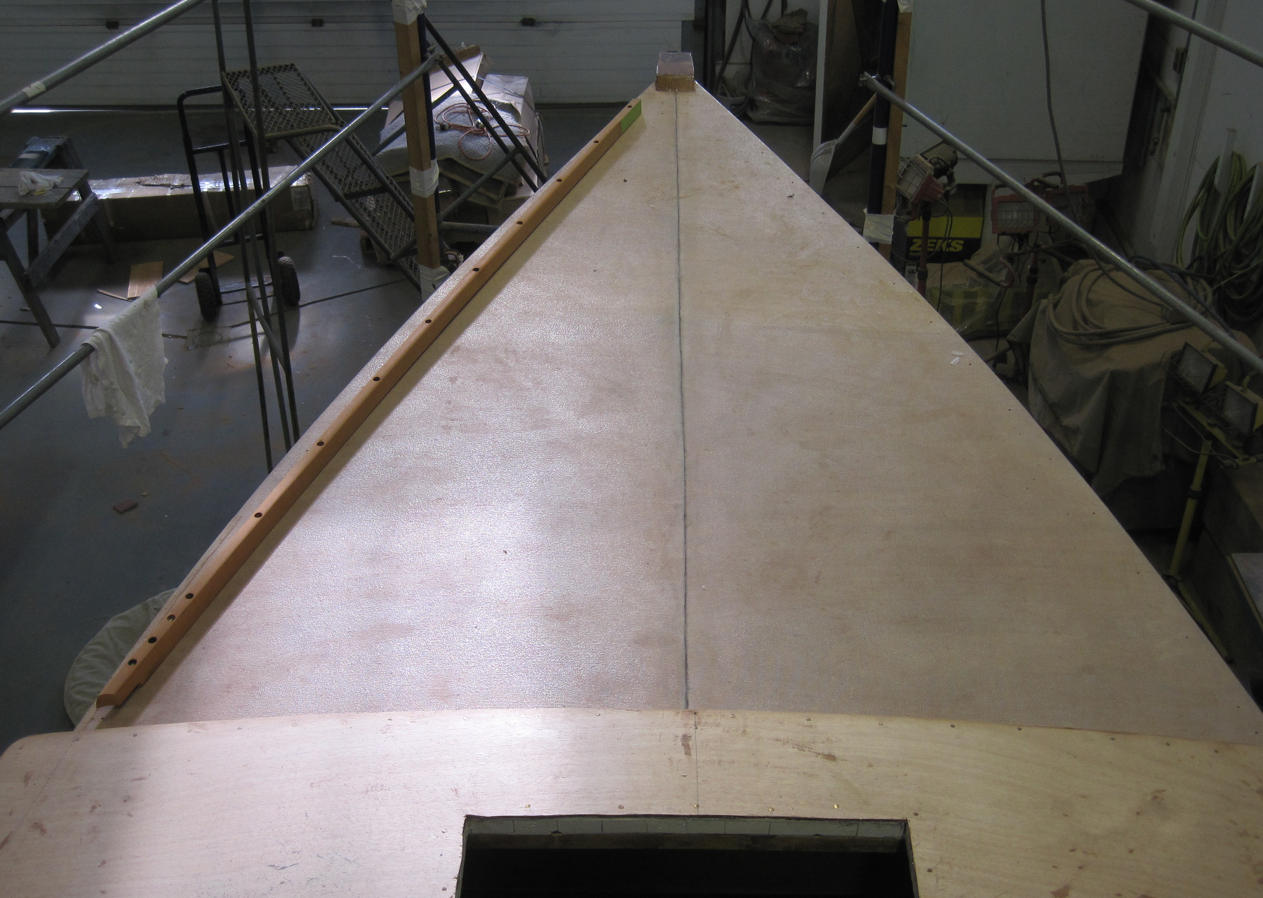 Wooden Boat Restoration - Kestrel - Fast forward and here is Kestrel's bow with new stem work, new plywood, and sheathed in Dynel.